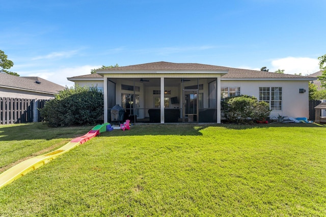 back of property featuring a yard, ceiling fan, and a sunroom