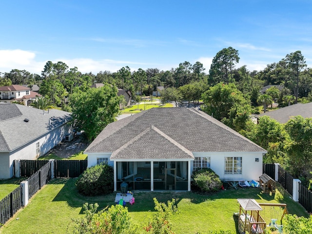 rear view of house with a sunroom and a lawn