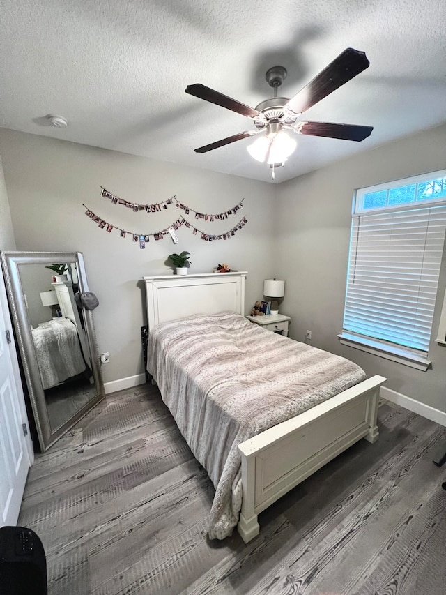 bedroom with dark hardwood / wood-style flooring, a textured ceiling, and ceiling fan