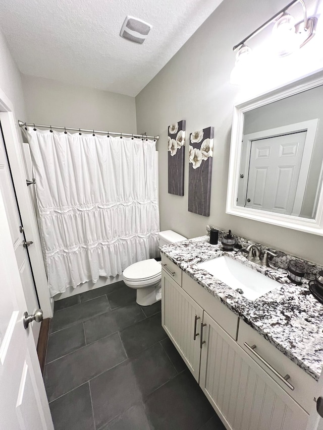 bathroom featuring a textured ceiling, toilet, vanity, a shower with shower curtain, and tile patterned flooring