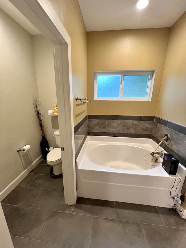 bathroom with toilet, tile patterned flooring, and a bathing tub