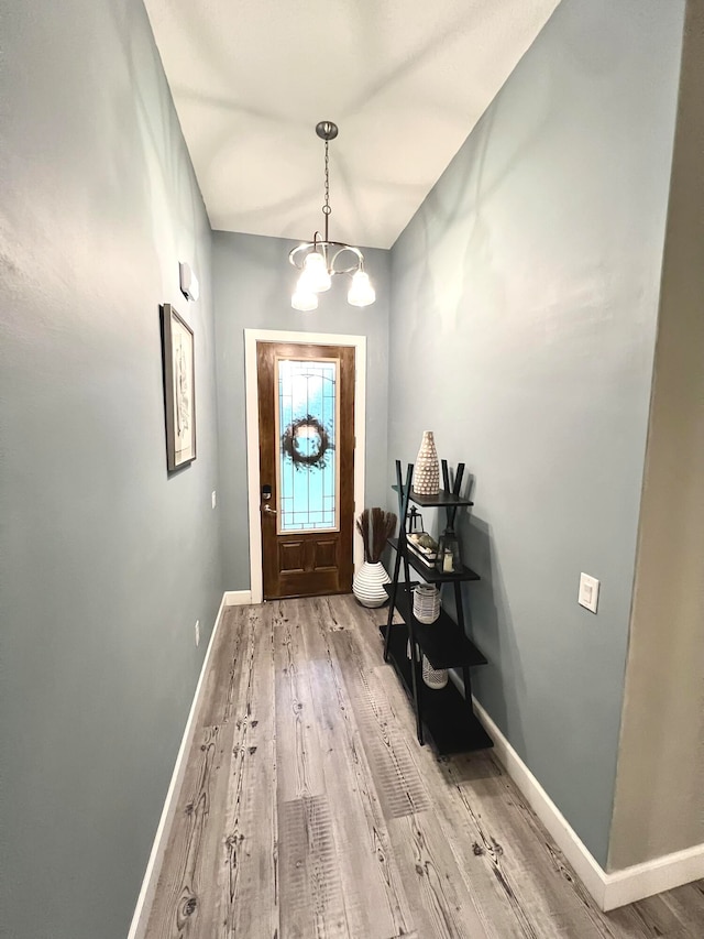 entryway featuring hardwood / wood-style flooring and a chandelier