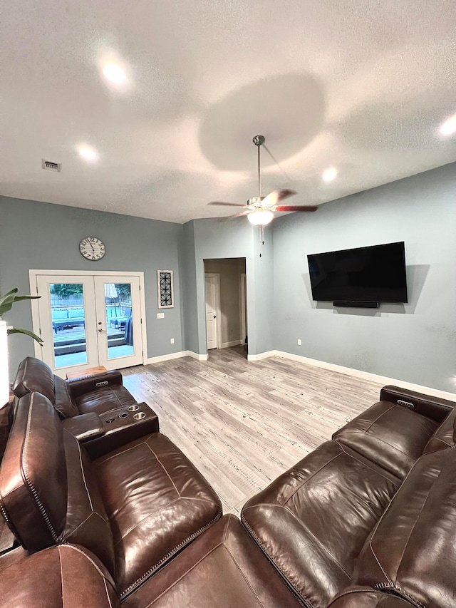 living room with a textured ceiling, hardwood / wood-style flooring, french doors, and ceiling fan