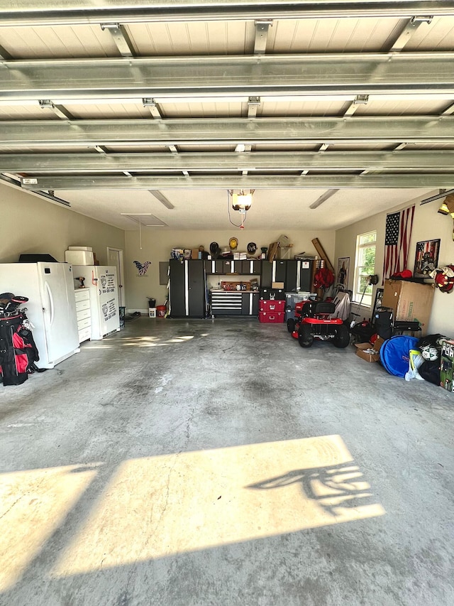 garage with a garage door opener and white fridge