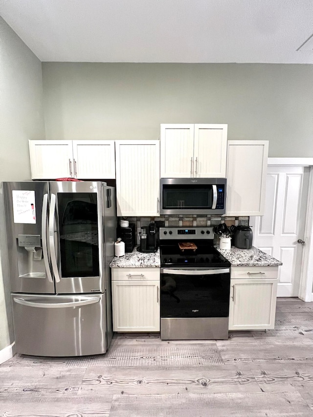 kitchen featuring white cabinets, stainless steel appliances, and light hardwood / wood-style floors