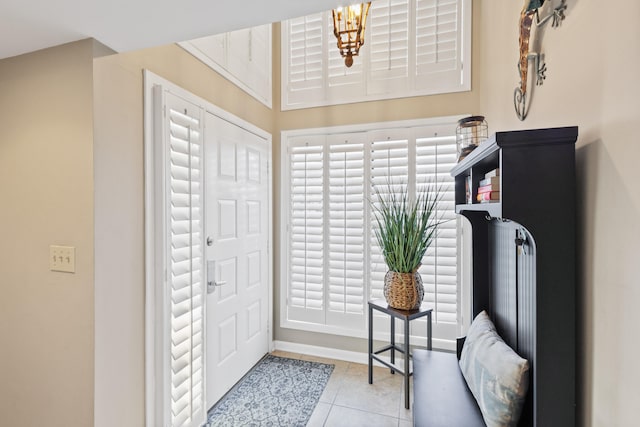 entryway featuring an inviting chandelier and light tile patterned floors