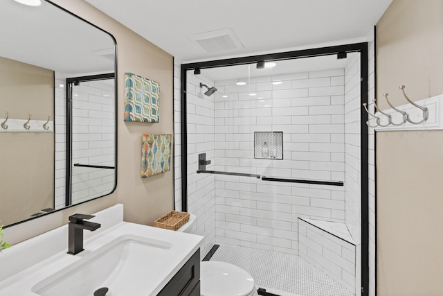 bathroom with vanity, a shower with shower door, and toilet