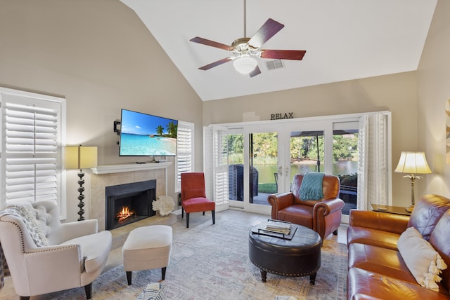 tiled living room with french doors, high vaulted ceiling, a fireplace, and ceiling fan