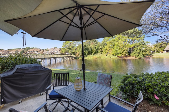 wooden terrace featuring a water view, grilling area, and a yard