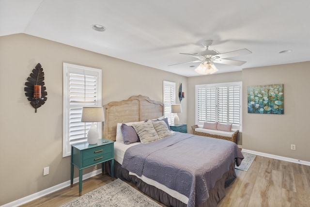 bedroom featuring lofted ceiling, light hardwood / wood-style flooring, and ceiling fan