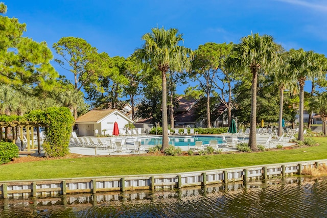 view of swimming pool featuring a yard and a water view