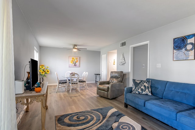 living room featuring wood-type flooring and ceiling fan