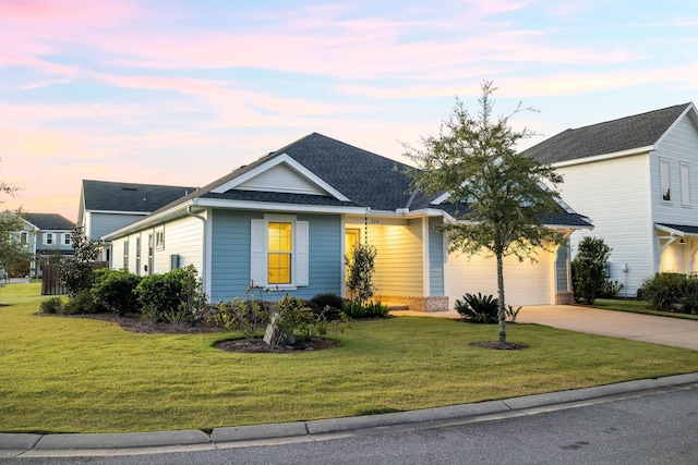 view of front of property featuring a shingled roof, an attached garage, a front lawn, and driveway
