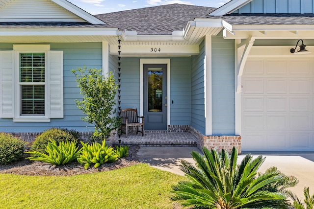 entrance to property featuring a garage and a lawn