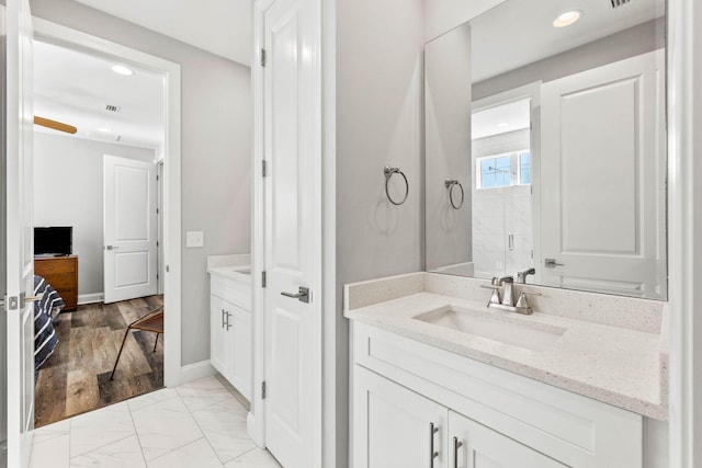 full bathroom with baseboards, recessed lighting, marble finish floor, a shower, and vanity