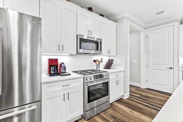 kitchen featuring decorative backsplash, dark hardwood / wood-style flooring, white cabinetry, crown molding, and stainless steel appliances