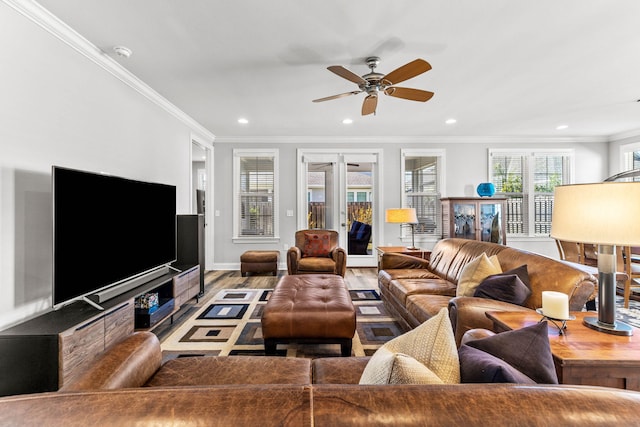 living area with wood finished floors, ornamental molding, and ceiling fan