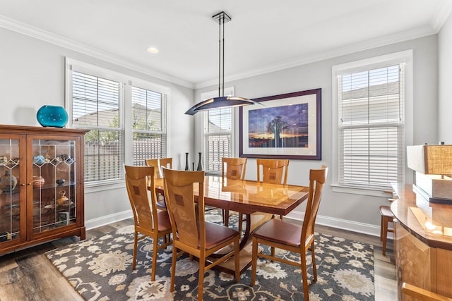 dining room featuring wood finished floors, baseboards, and ornamental molding
