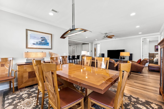 dining area featuring ornamental molding, light hardwood / wood-style floors, and ceiling fan