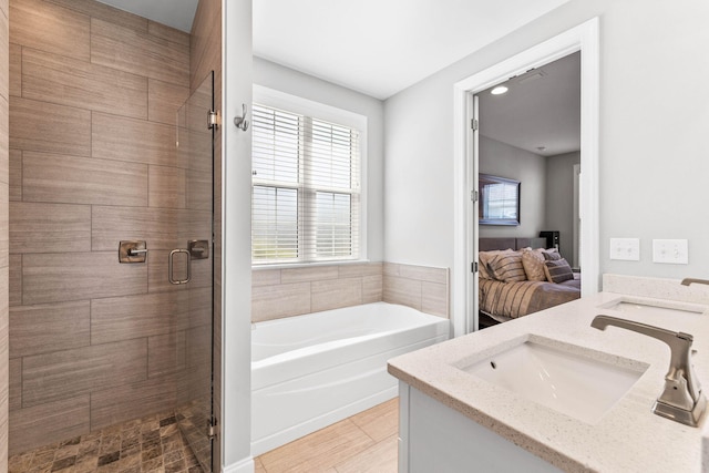 ensuite bathroom with a sink, double vanity, a shower stall, a garden tub, and ensuite bath
