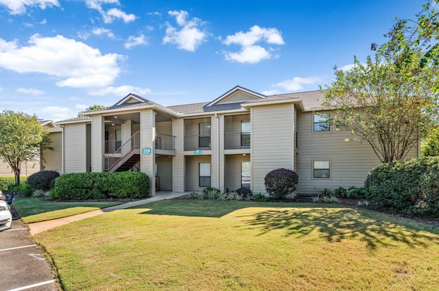 view of front of property with a front yard and a balcony