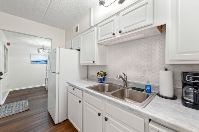 kitchen with white cabinets, backsplash, dark hardwood / wood-style flooring, sink, and white refrigerator