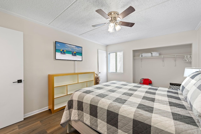 bedroom featuring a textured ceiling, dark hardwood / wood-style floors, a closet, and ceiling fan