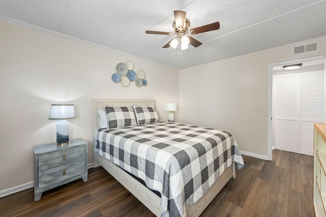 bedroom with ceiling fan, crown molding, a textured ceiling, and dark hardwood / wood-style floors