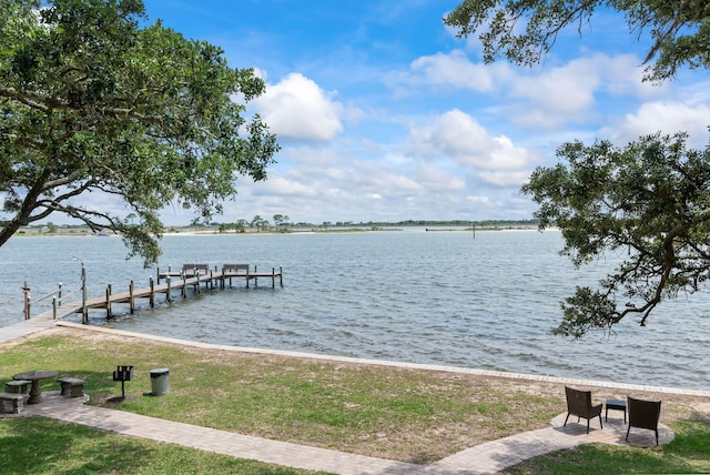 view of dock featuring a water view and a yard