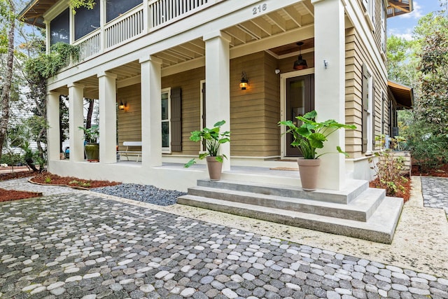 entrance to property featuring a balcony and covered porch