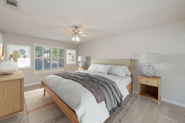 bedroom featuring carpet, ceiling fan, and a textured ceiling