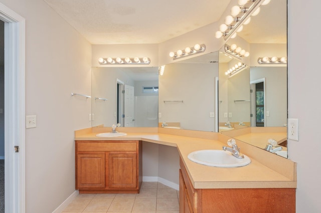 bathroom featuring tile patterned flooring, vanity, and a textured ceiling