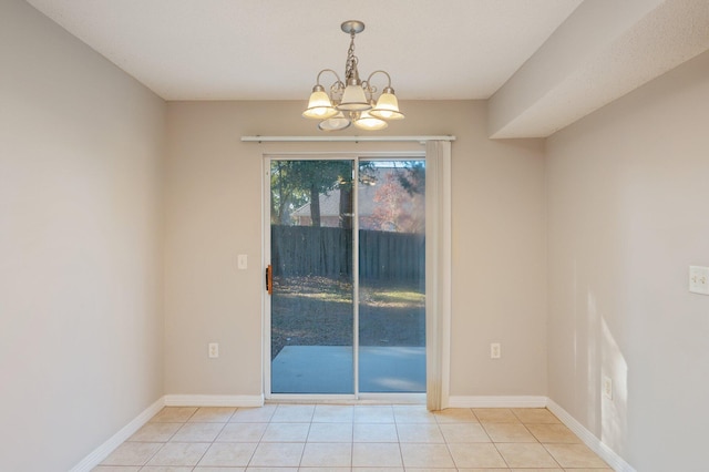 tiled empty room featuring an inviting chandelier