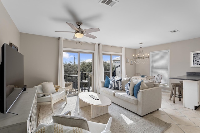 living room with light tile patterned floors and ceiling fan with notable chandelier