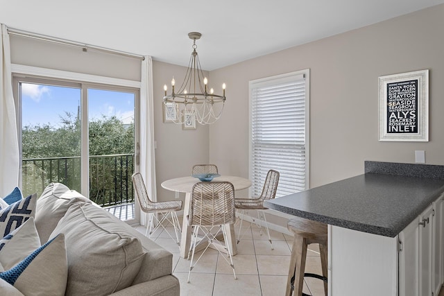 dining area with a wealth of natural light, light tile patterned flooring, and an inviting chandelier