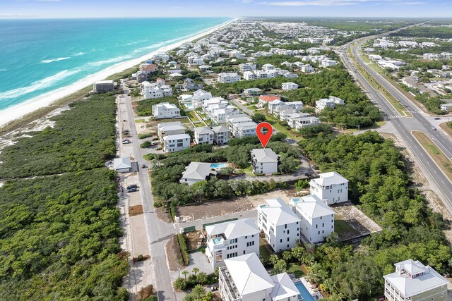 birds eye view of property with a water view and a beach view