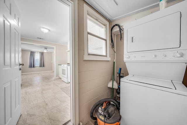 clothes washing area featuring stacked washer / drying machine and ceiling fan