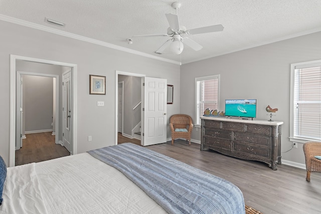 bedroom with multiple windows, wood-type flooring, and ceiling fan