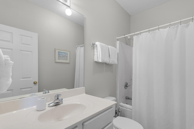 full bathroom with vanity, toilet, a textured ceiling, and shower / bath combo