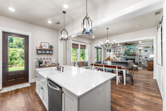 kitchen with dark hardwood / wood-style floors, plenty of natural light, and a center island with sink