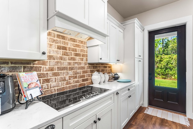 kitchen featuring tasteful backsplash, light stone countertops, black electric cooktop, white cabinetry, and dark hardwood / wood-style floors