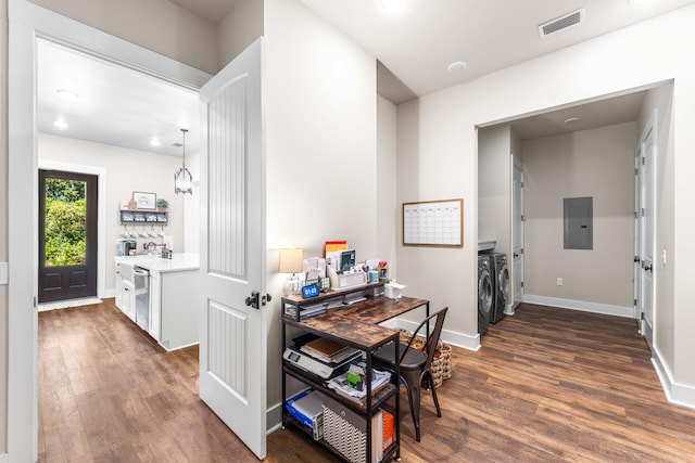 kitchen featuring electric panel, washer and clothes dryer, and dark hardwood / wood-style flooring