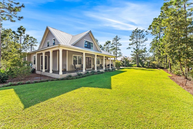 back of house with covered porch and a lawn