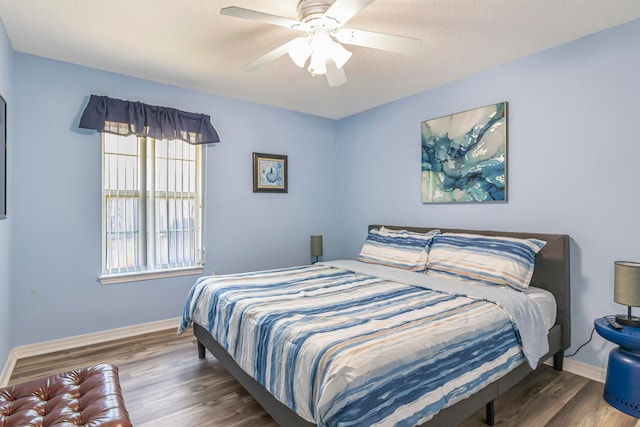 bedroom featuring dark hardwood / wood-style floors, a textured ceiling, and ceiling fan