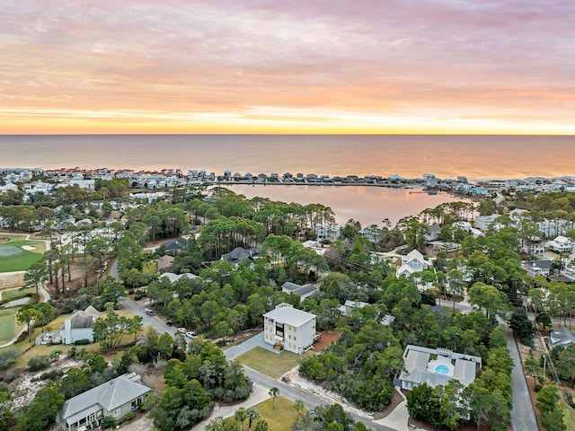 aerial view at dusk featuring a water view