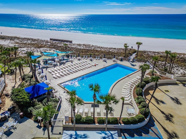 view of swimming pool featuring a water view and a view of the beach