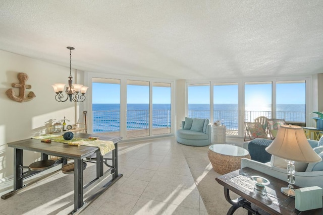 sunroom with a notable chandelier and a water view