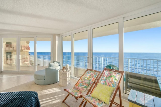 sunroom featuring a water view