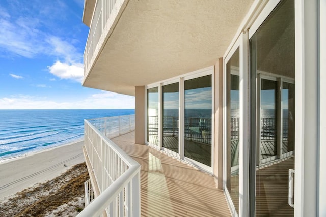 balcony featuring a water view and a view of the beach