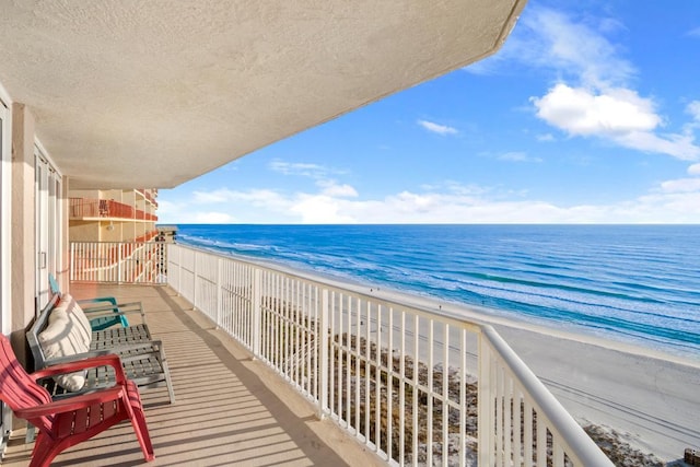 balcony with a water view and a beach view